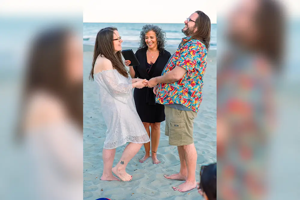 Couple exchanging vows on a beach.