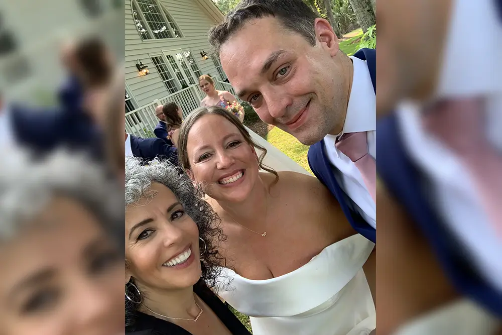 Bride and groom with guest at wedding.